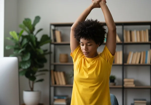 Person taking a short break, stretching away from computer.